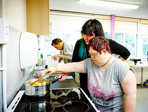 approach8 Female cooking in kitchen