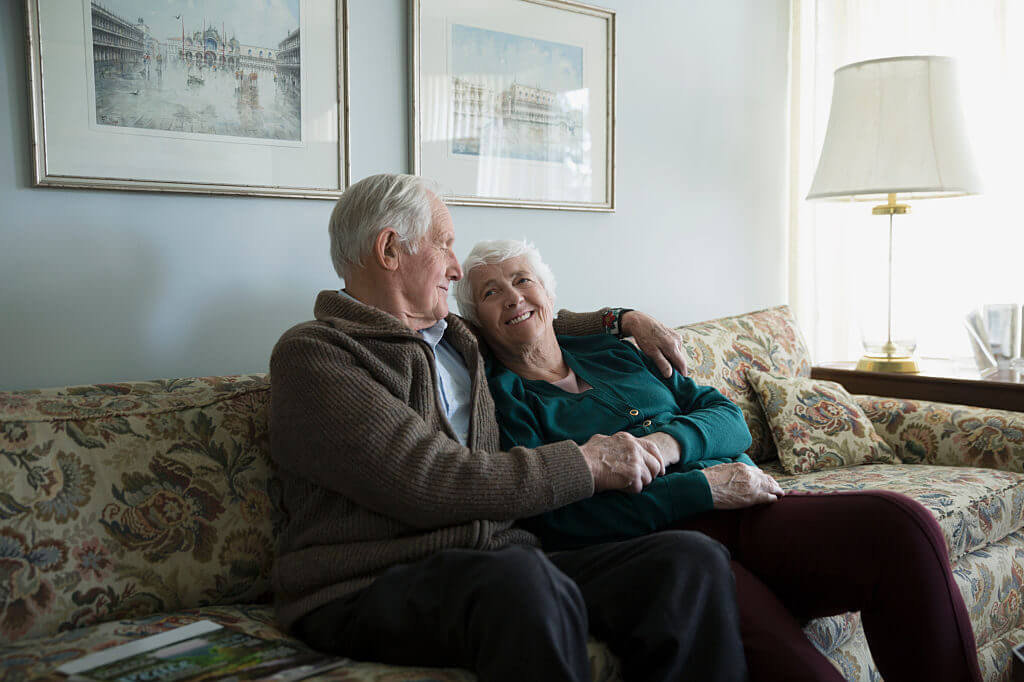 content-hub Older couple sitting on couch smiling