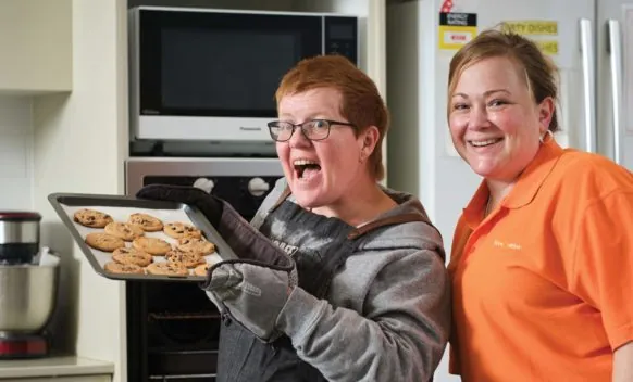 two happy people in kitchen baking cookies