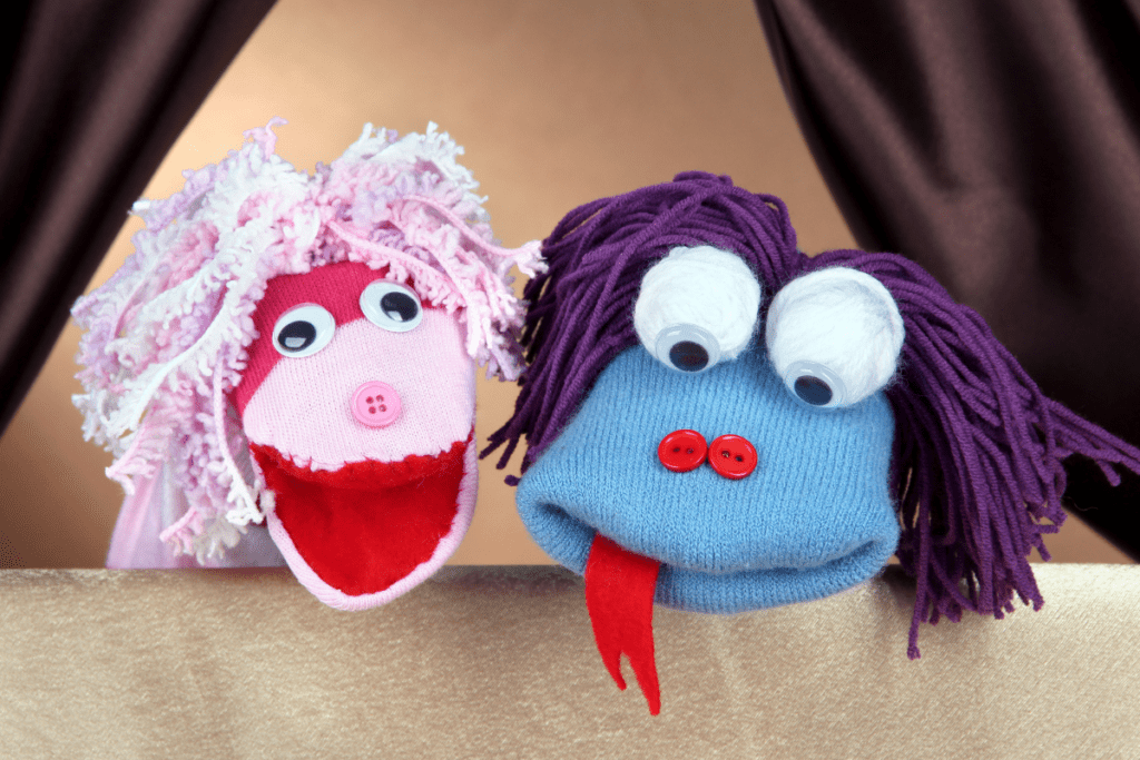 Two sock puppets with yarn hair and big googly eyes